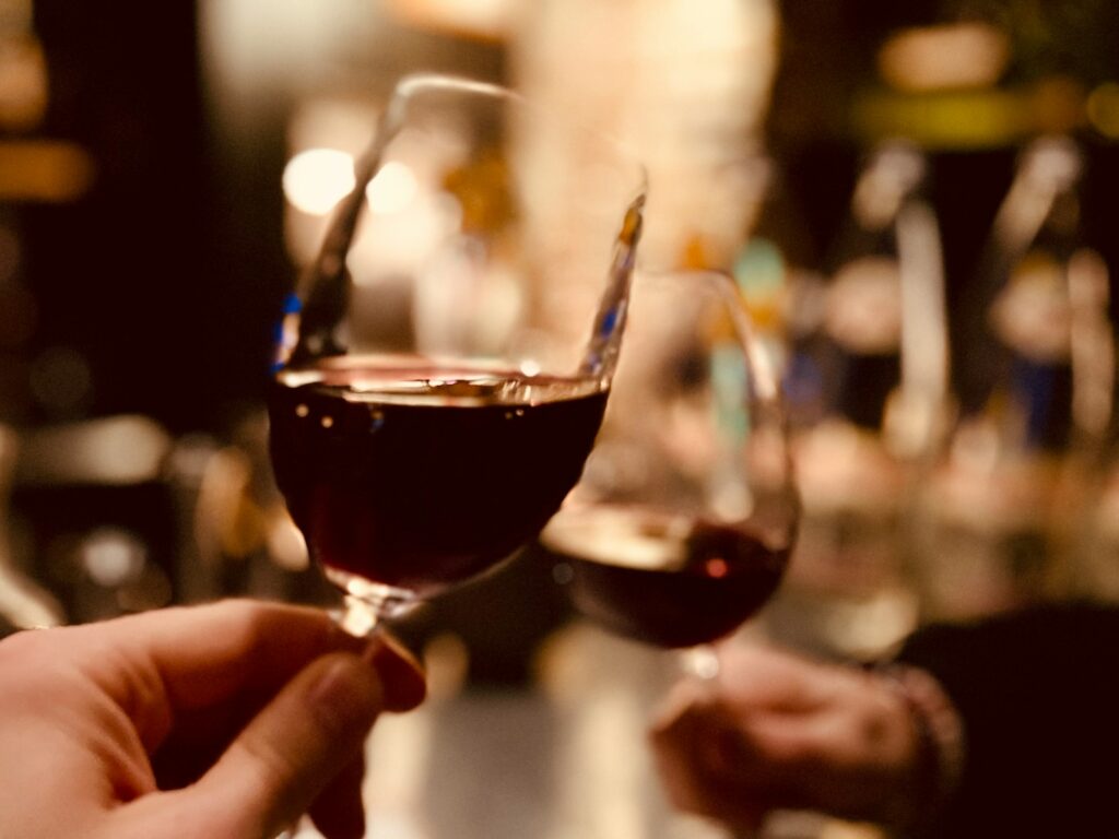 a person holding a glass of wine in their hand